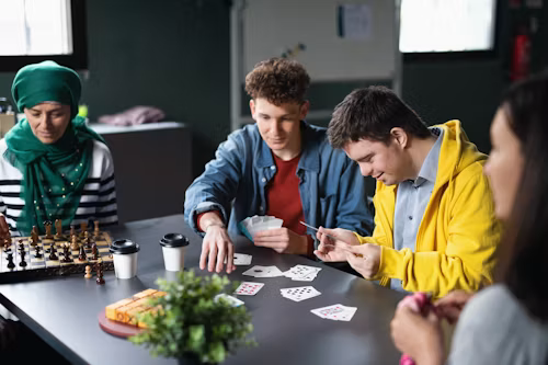 Des jeunes jouant ensemble autour d’une table